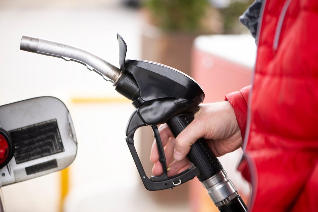 Hand refilling the car with fuel at the refuel station